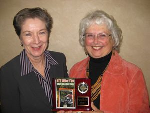 Cheryl Tevis (left), 2008 recipient, presents plaque to Jan Goldsmith