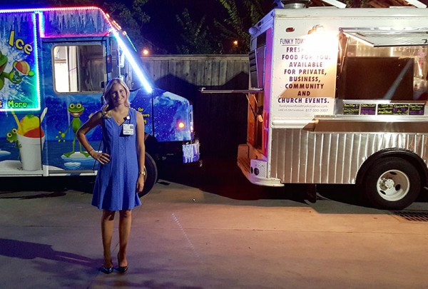 Chelsea Van Vark stands outside with several of the food trucks she helped coordinate.
