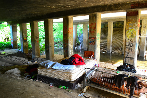 photo of a mattress under a bridge