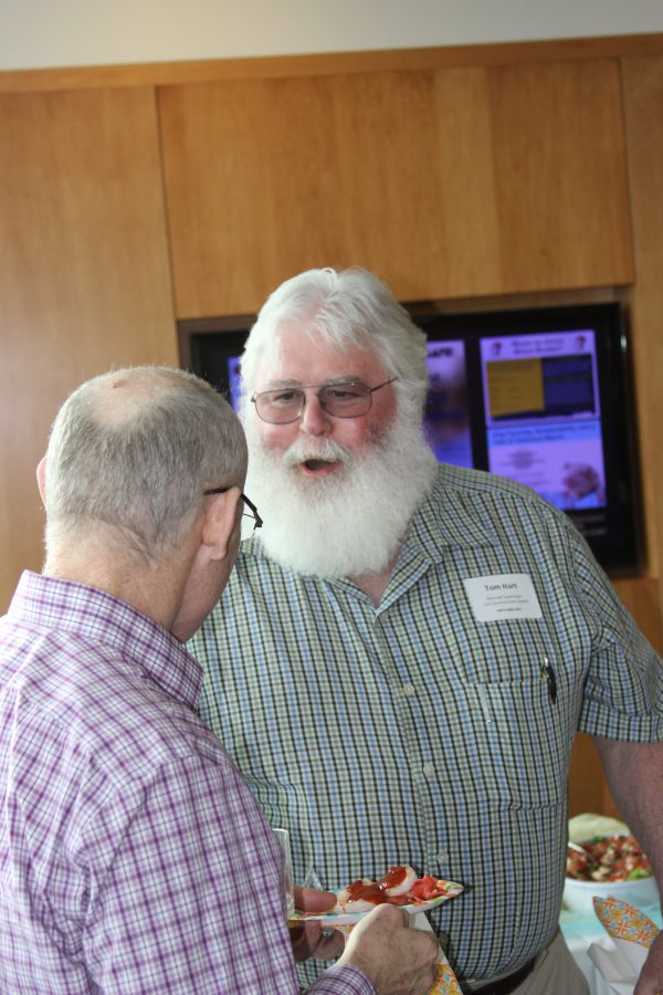 Occupational and Environmental Health alumnus Tom Hart chats with department head Peter Thorne.