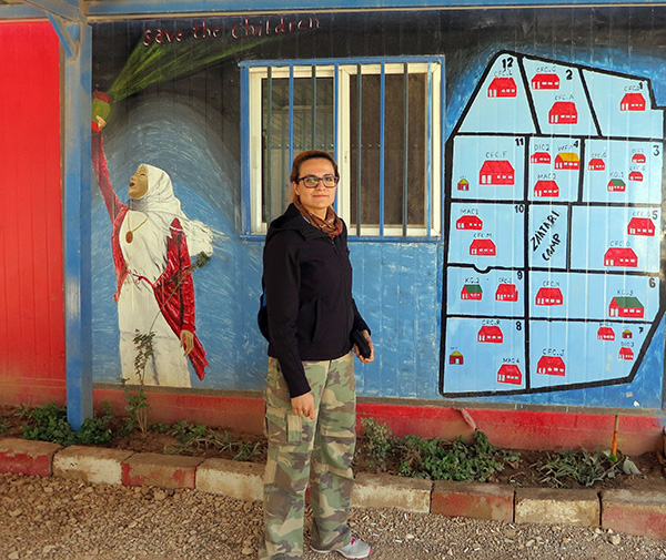 Tala A--Rousan stands by a map in Zaatari refugee camp