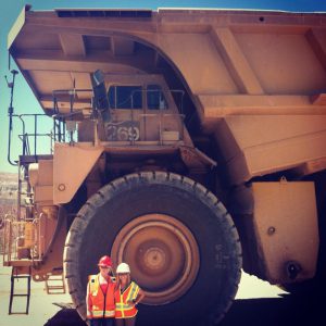 Jessica Mills next to a giant mining dump truck.