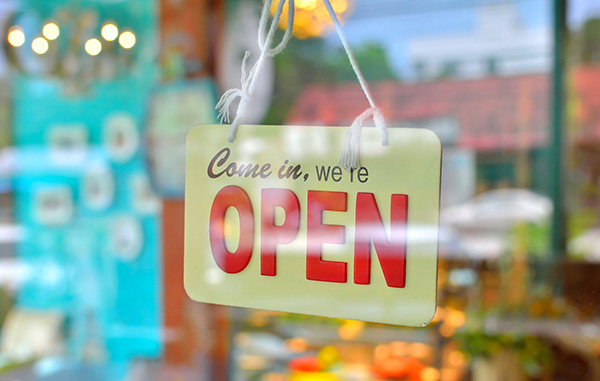 open sign broad through the glass of window at coffee shop