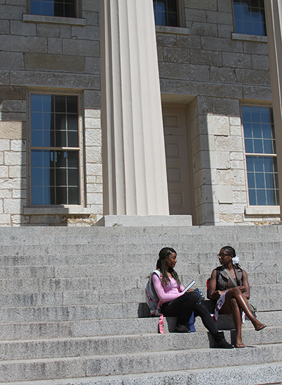 Students sit on the steps of the Old Capitol on the University of Iowa campus.