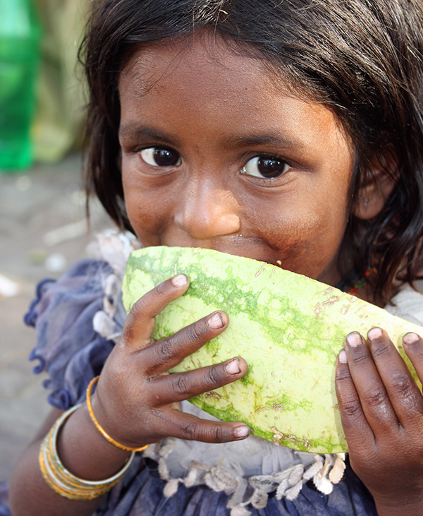 A girl in India eating watermelon.