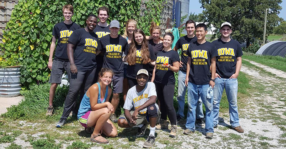 A group of College of Public Health students volunteering at a local farm during a day of service