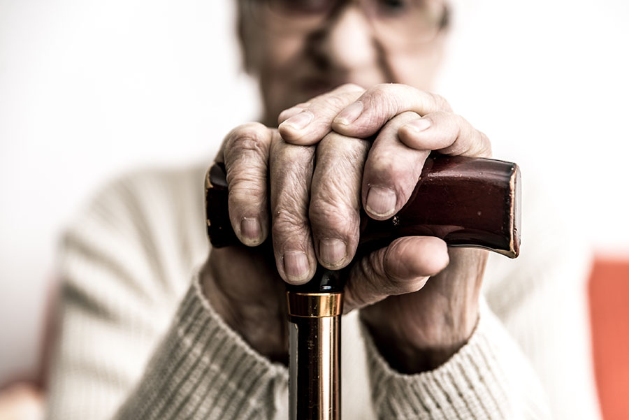 close up of elderly hands on a cane