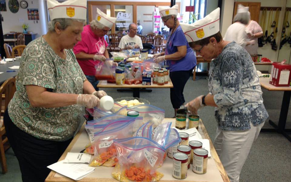 Volunteers in Cass County assemble meal preparation kids for seniors.