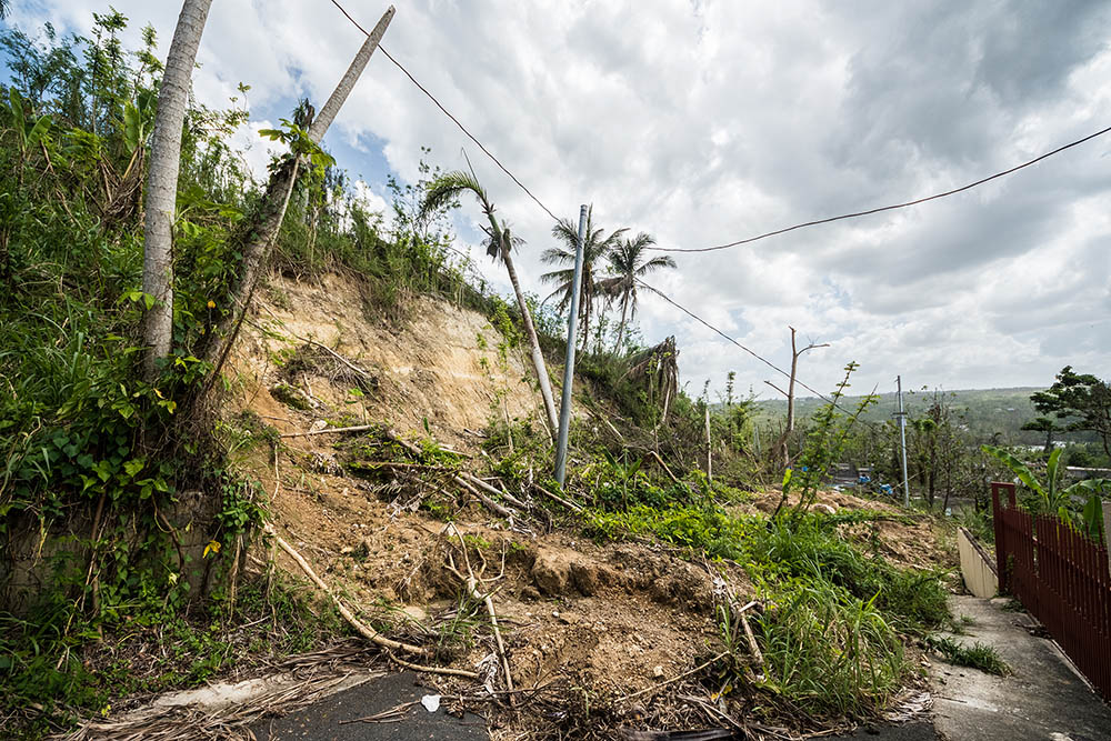 Roadway covered with mudslide from saturated hillside along highway in Puerto Rico