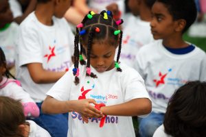A child checks her wrist band and the Healthy LifeStars event