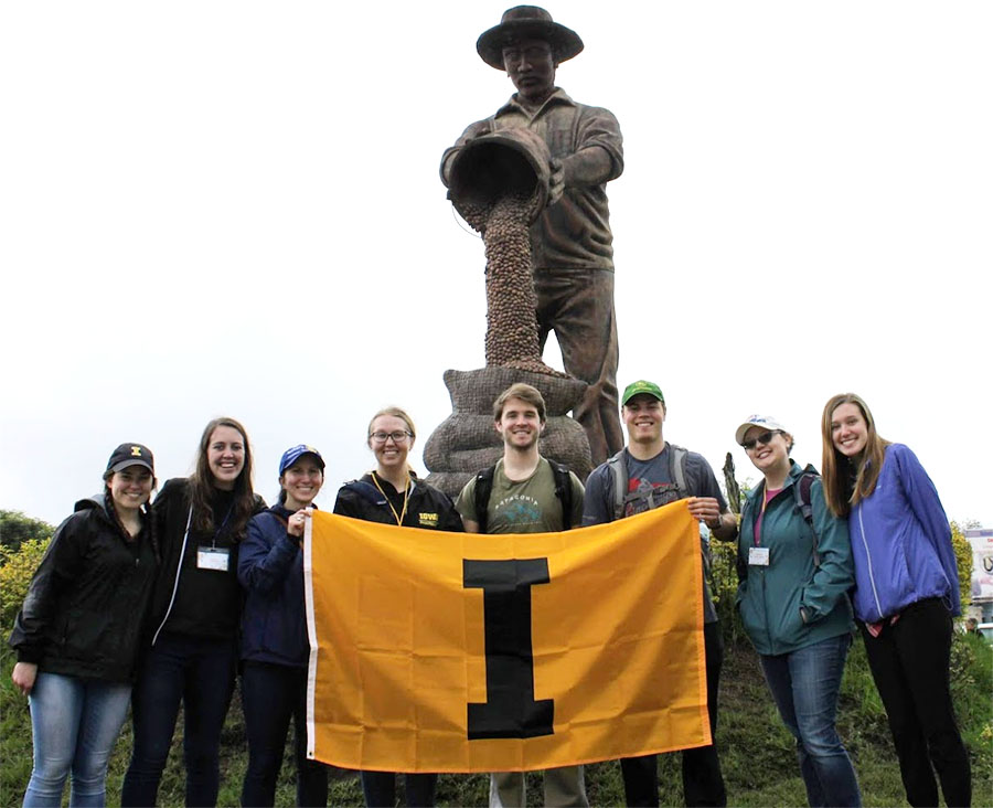 a group of students hold a University of Iowa banner