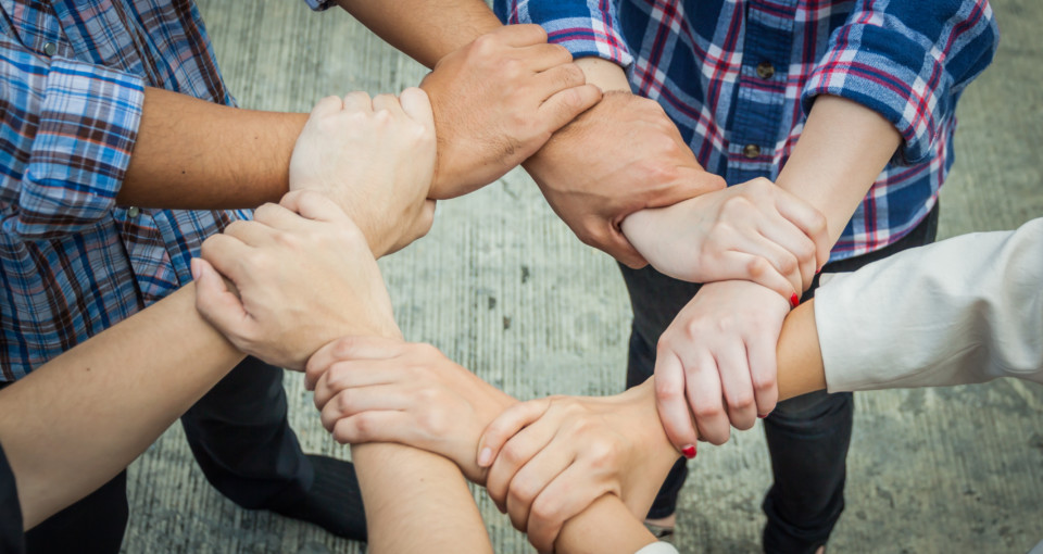 Business team standing hands together in the loft office