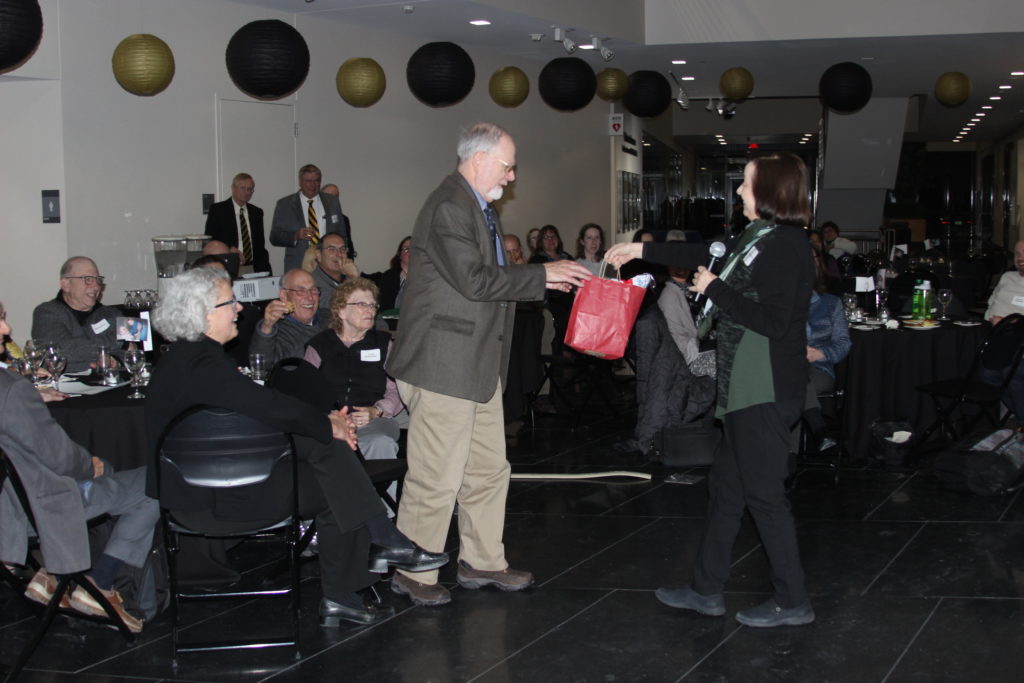 Nancy Sprince presents a gift to Robert Wallace at Wallace's retirement event.