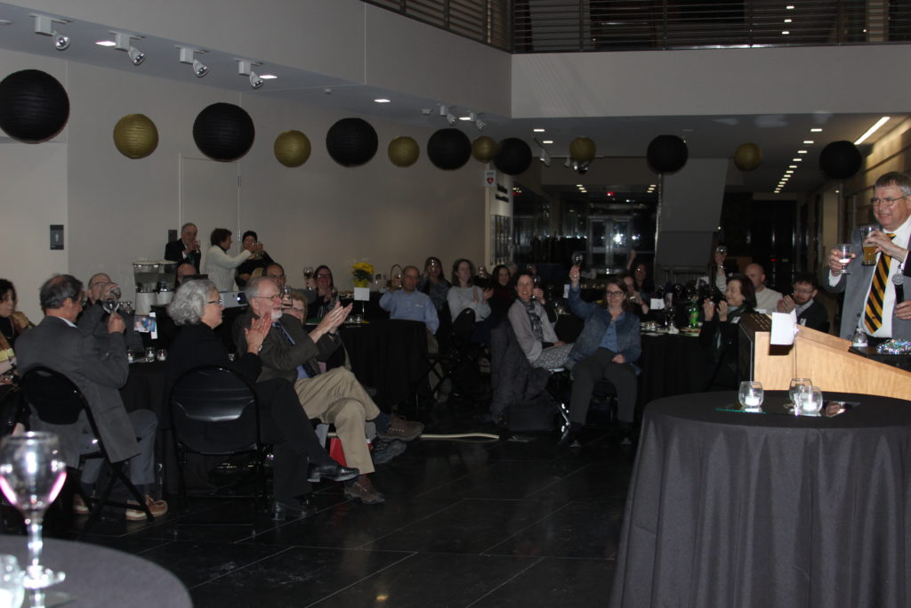 Attendees toast Robert Wallace's career at a retirement event honoring his work.