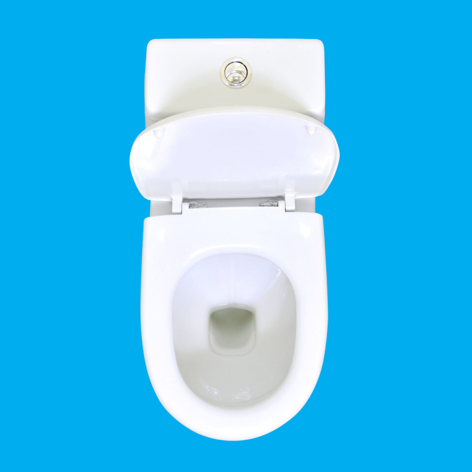White ceramic toilet on blue background. View above.