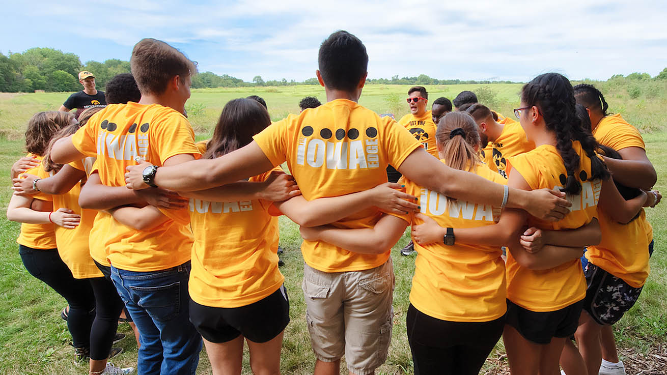 UI students in a huddle during a teambuilding exercise