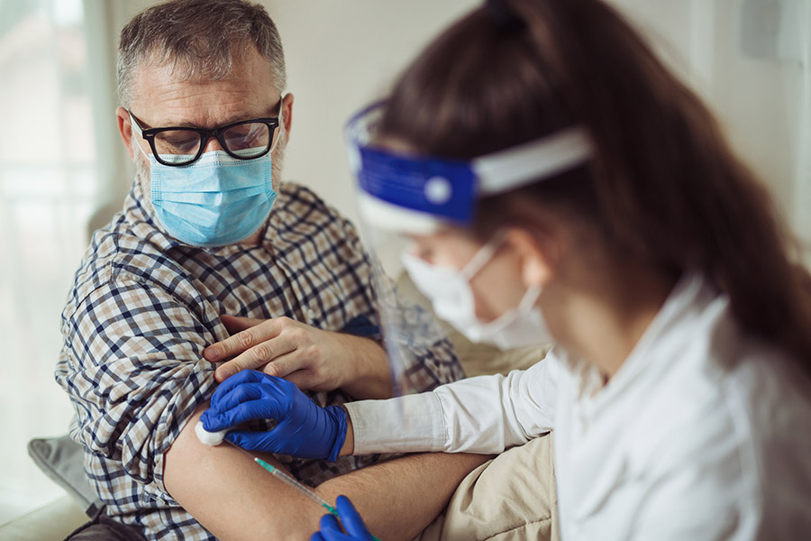 Nurse giving older man COVID vaccination