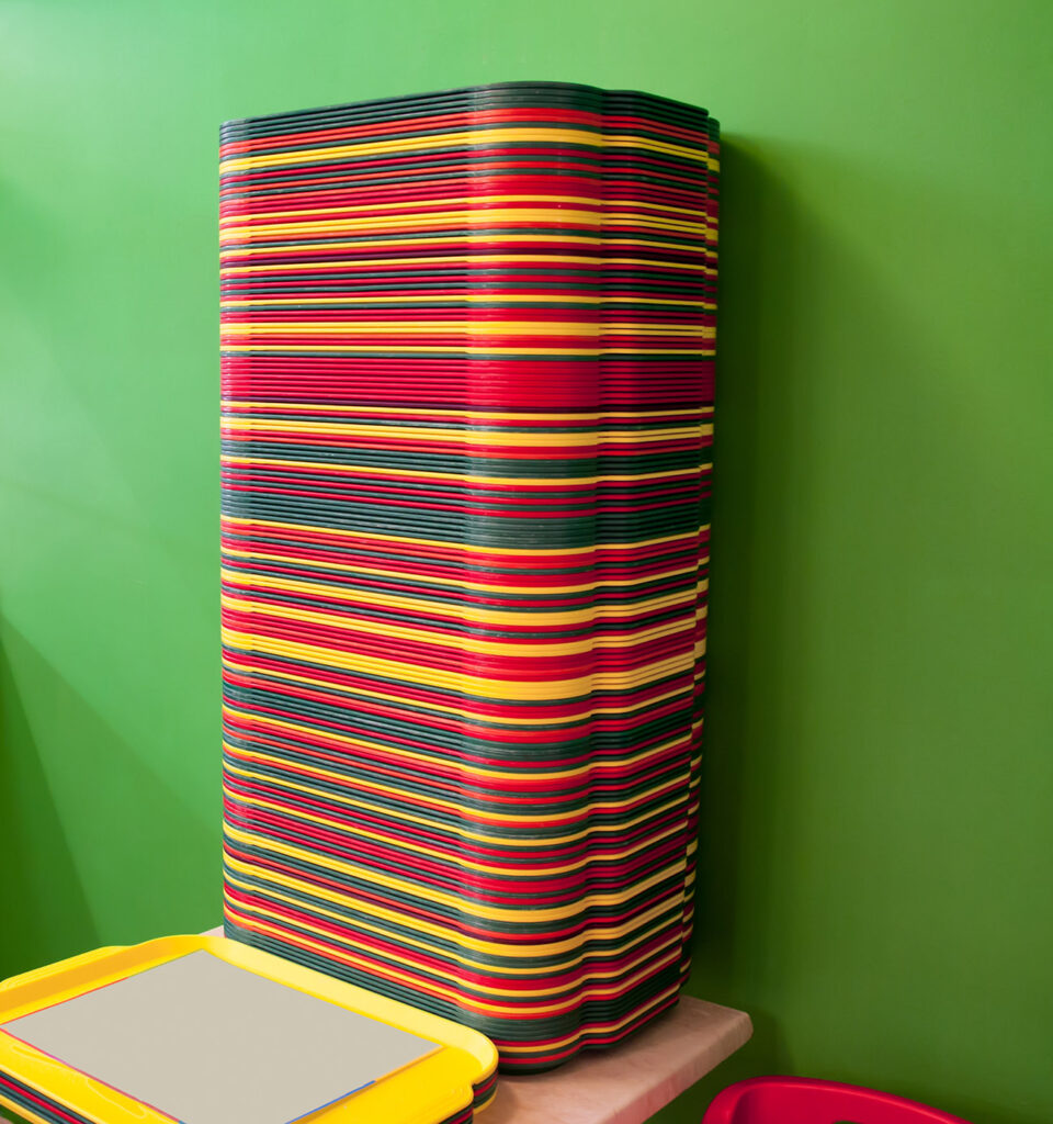 A stack of red, yellow, green trays on the table.
