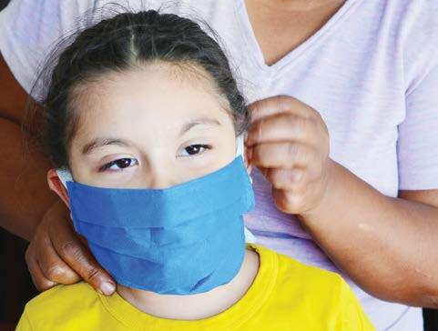 Woman helps girl with face mask