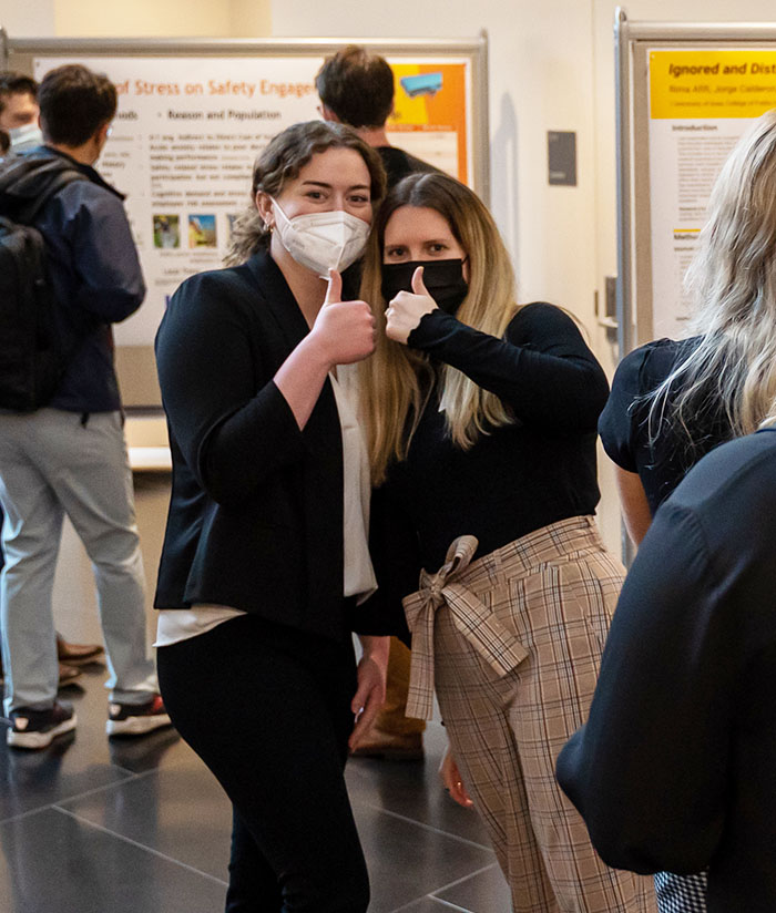 Two students give a thumbs up during the 2022 OSH Student Conference poster session