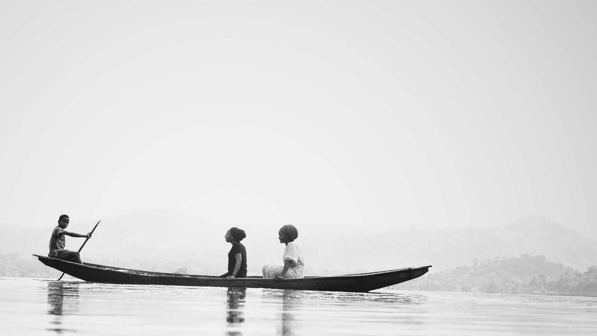 three people boating in a long, thin canoe