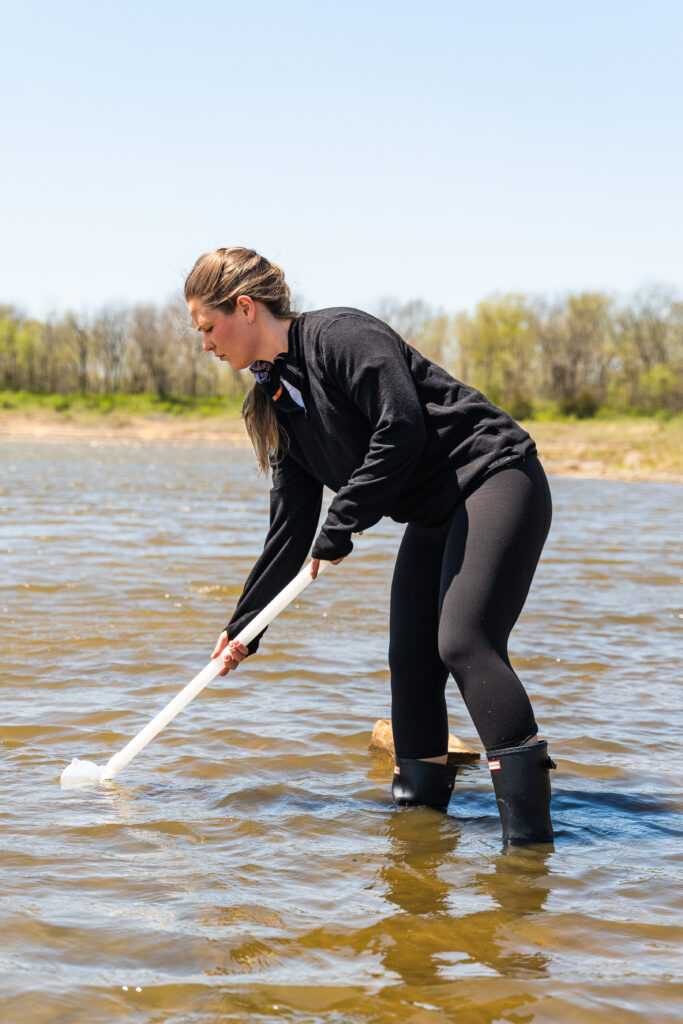 Lyndy Holdt collects a water sample.