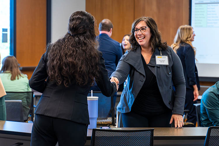 MHA students and alumni greet each other at a speed networking event.