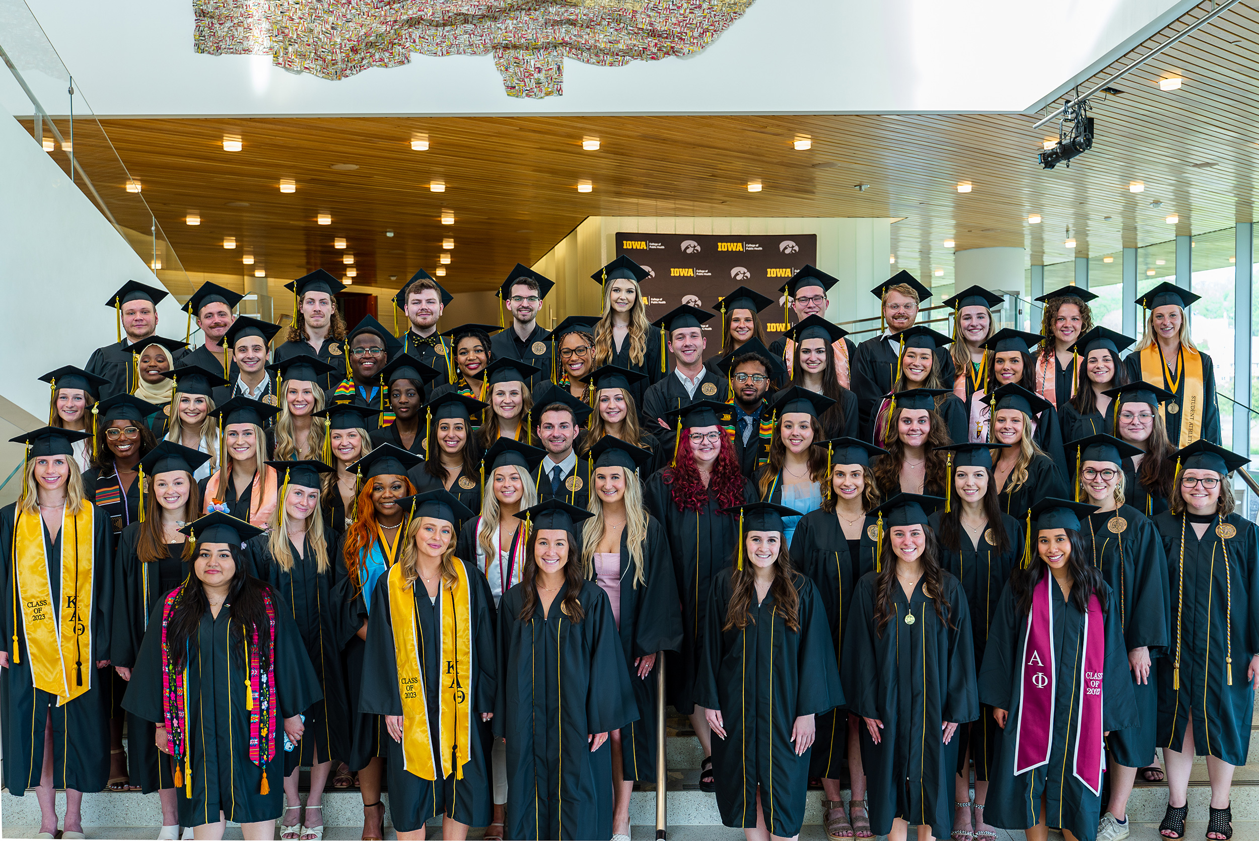 The College of Public Health Undergraduate Class of 2023 poses on the stairwell at Hancher Auditorium.