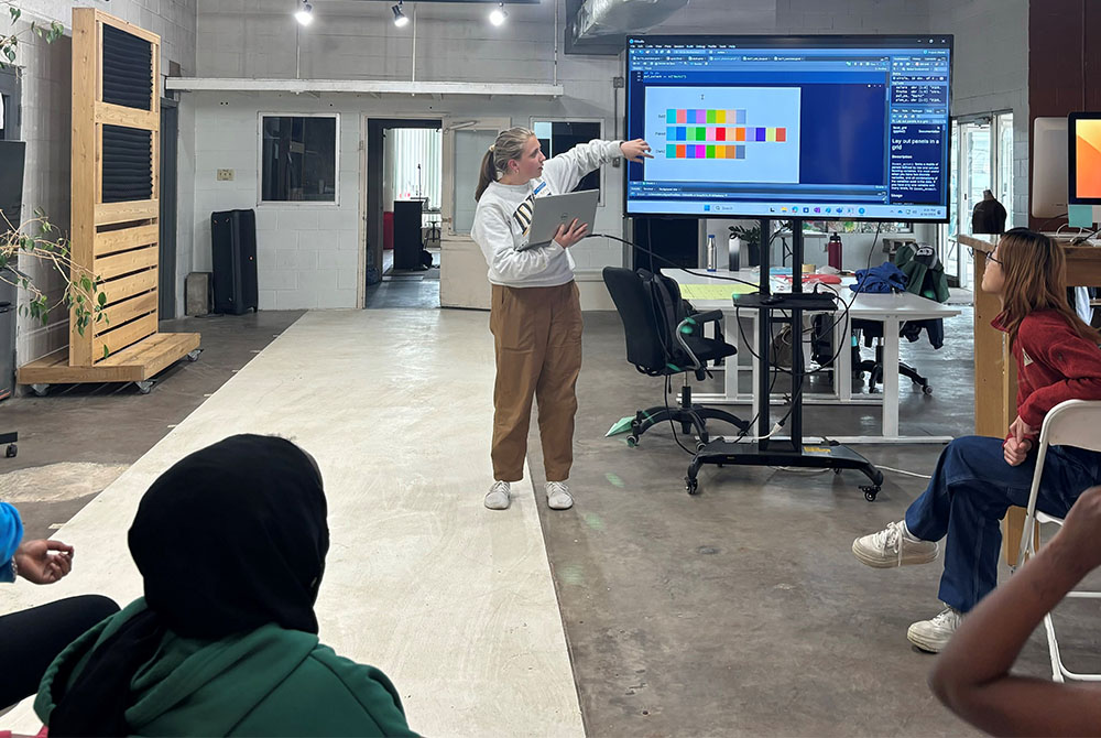 a biostats graduate student explains data on a screen to girls at an after school program