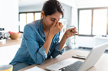 Stressed woman sitting at laptop