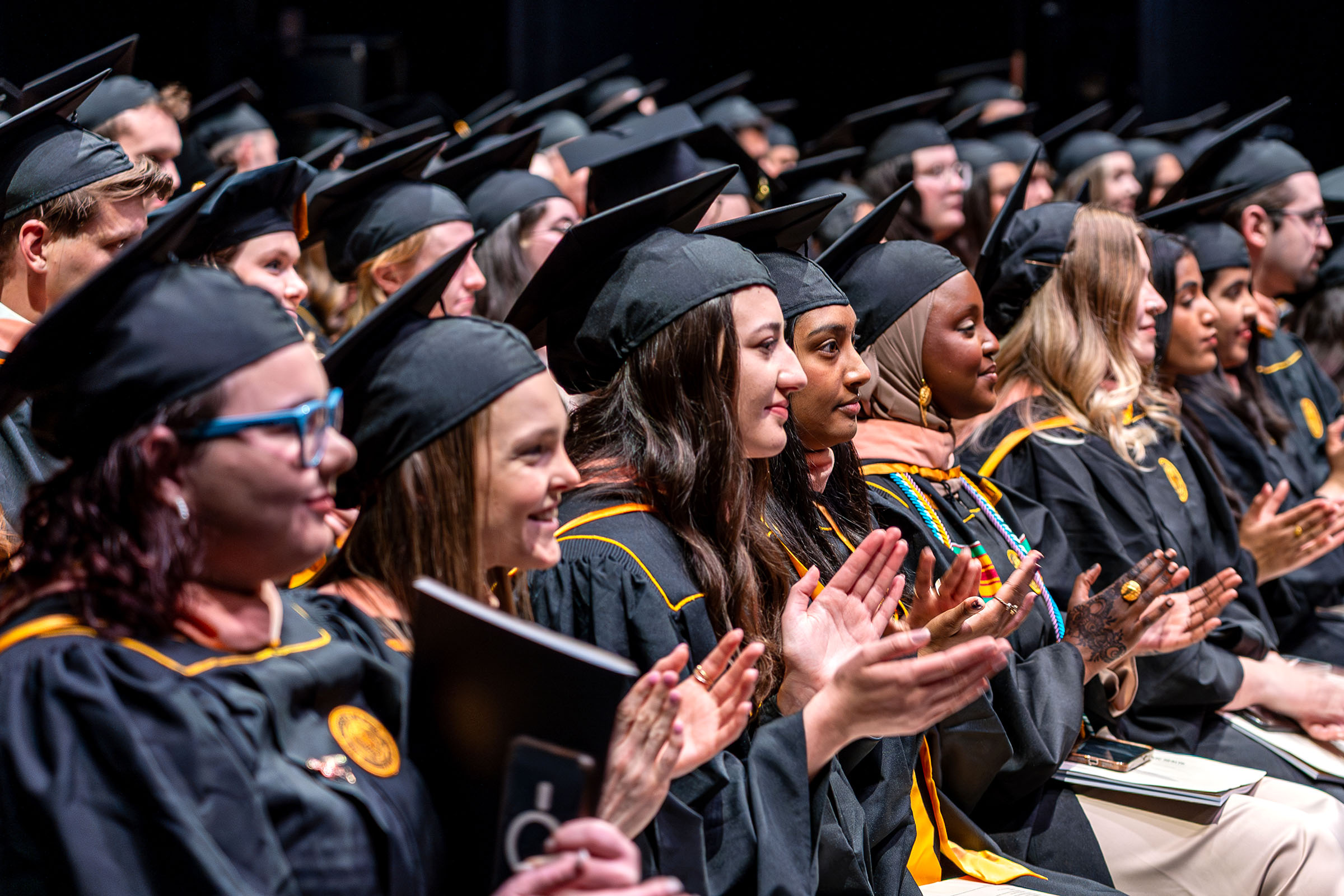 Graduating students applaud at the 2025 College of Public Health commencement ceremony.