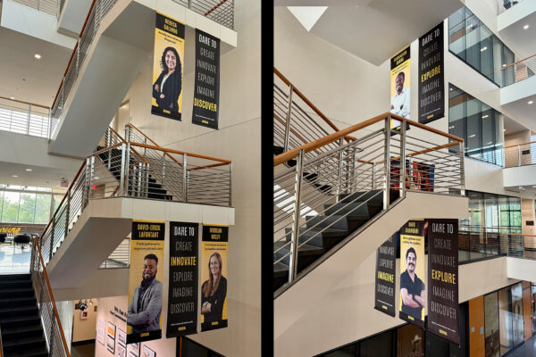 'Dare to Discover' banners featuring student researchers hang in the College of Public Health Building atrium.