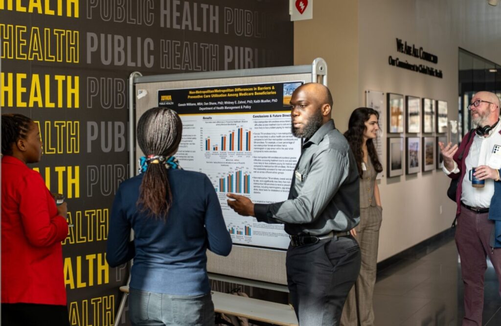 Students discuss research findings at a recent poster session at the College of Public Health Building.