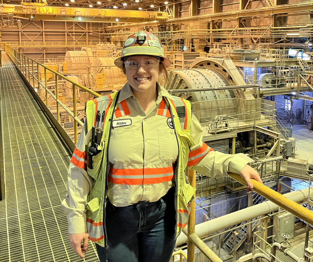Abigail Tompkins in front of mining equipment