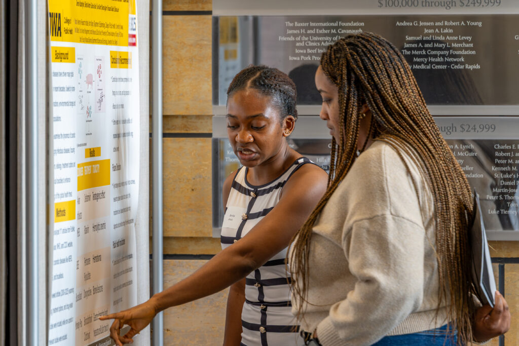 Students looking at a research poster during 2025 Research Week at the College of Public Health.