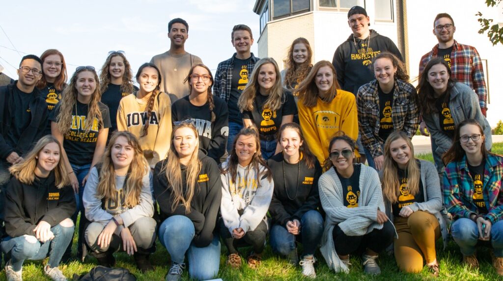 A group of UI College of Public Health students posing in Iowa apparel.