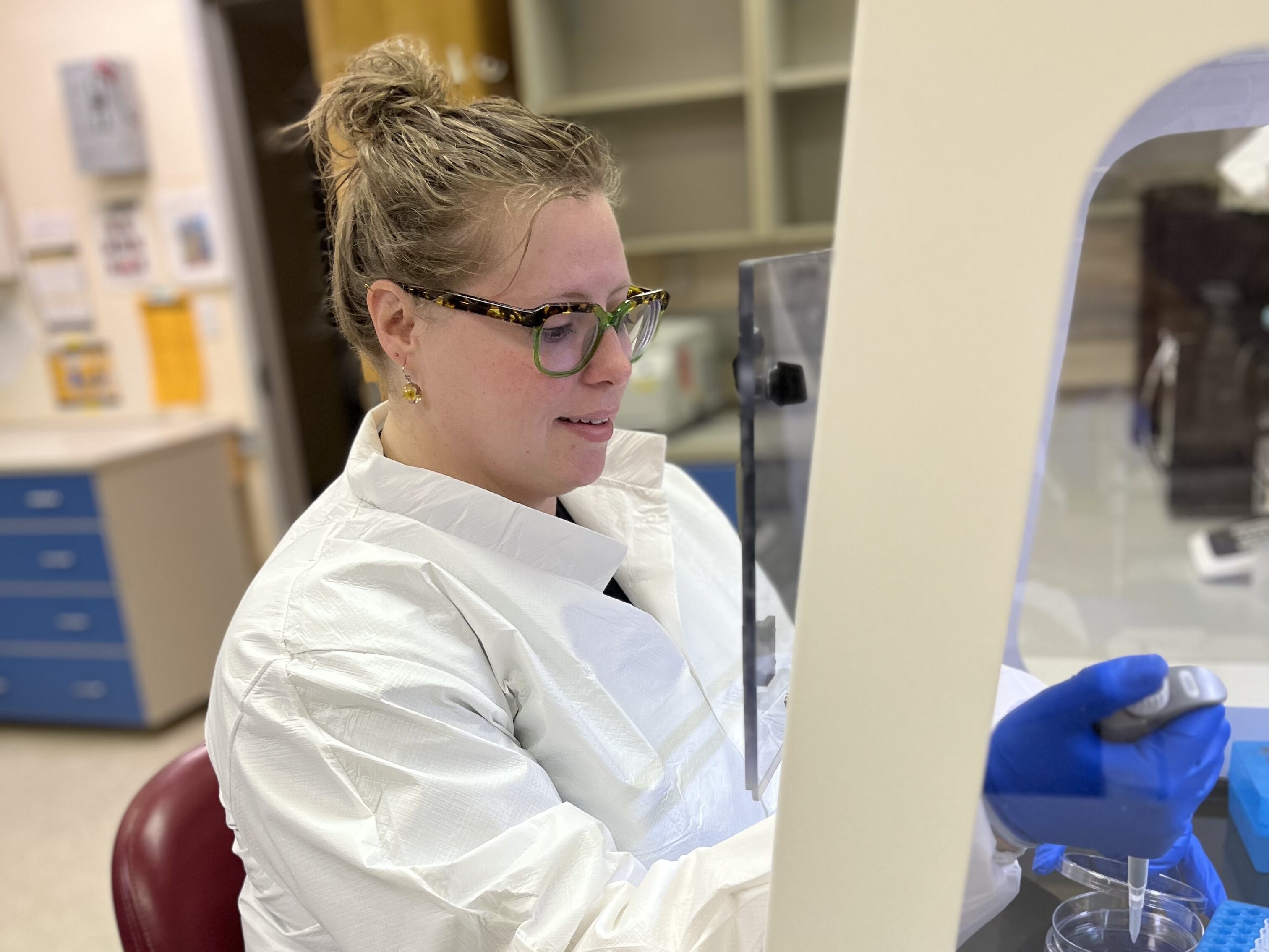 Prof. Shoshannah Eggers using a pipette and a Petri dish in a laboratory.